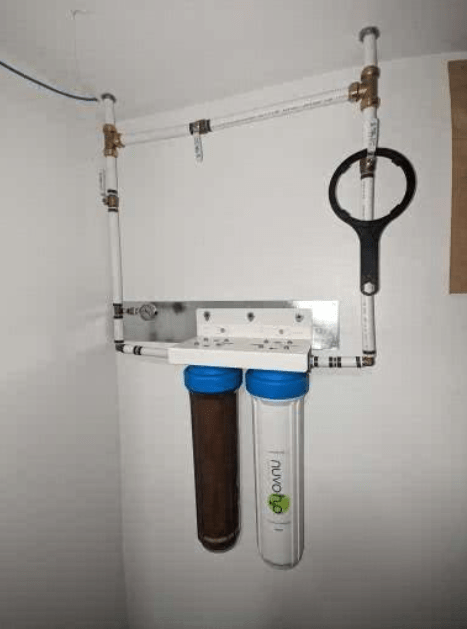 A water filter is hanging from the ceiling in a bathroom