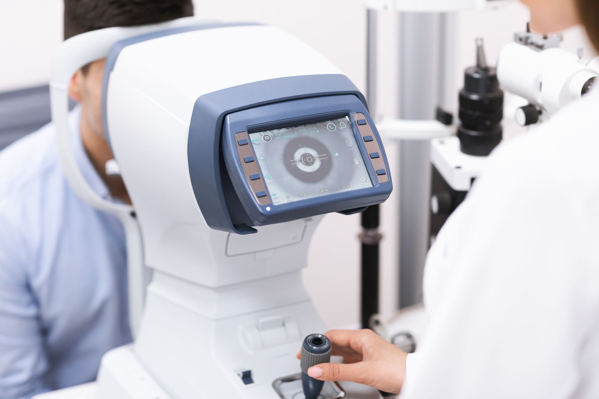 Ophthalmologist consultation using advanced cataract eye exam equipment in a clinical setting. Ophthalmologist consultation using advanced cataract eye exam equipment in a clinical setting.