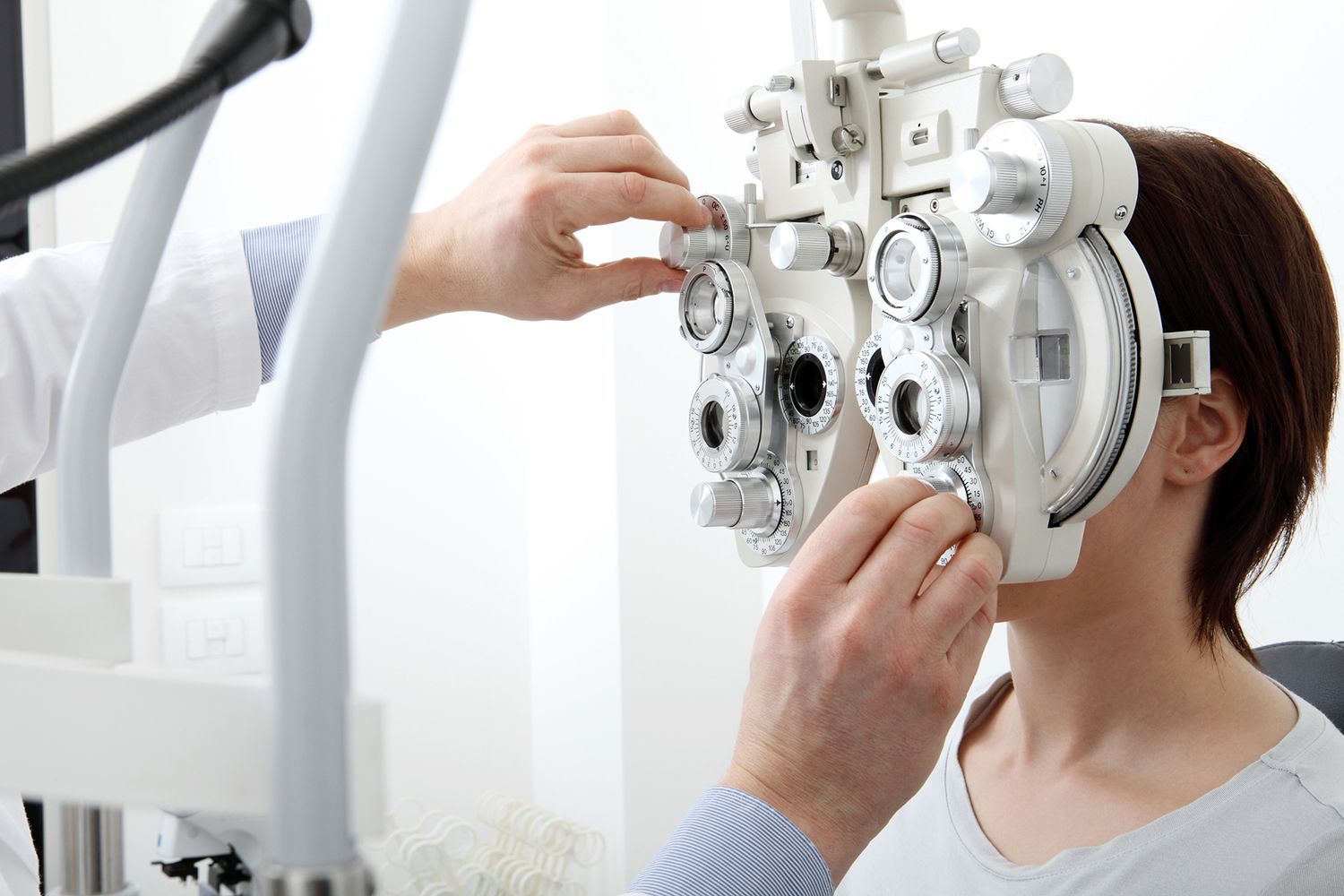 Optometrist adjusting phoropter during comprehensive eye exam for accurate vision correction.