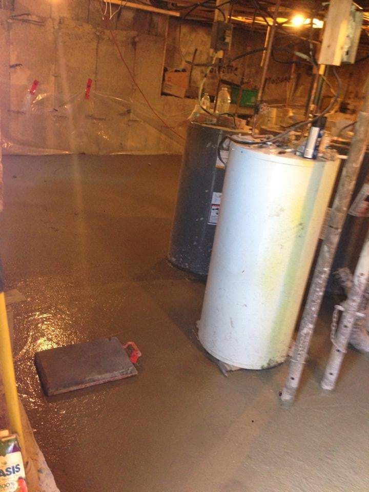 Un chauffe-eau est posé sur le sol d'un sous-sol.