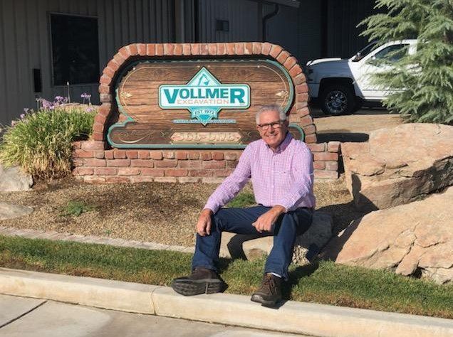 Property Grading — Bob Sitting Beside The Vollmer Signage in Fresno County, CA
