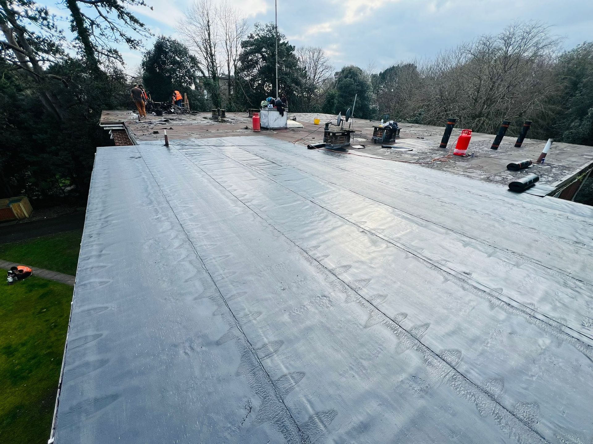 An aerial view of a roof with a lot of trees in the background.