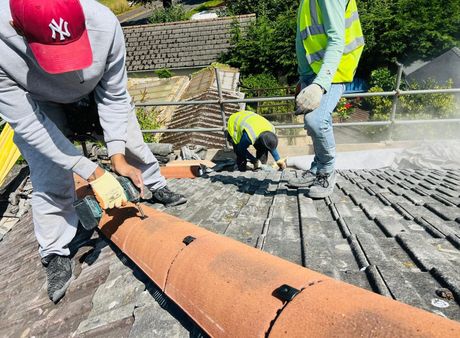 A man wearing a ny hat is working on a roof.