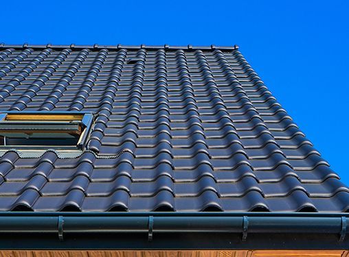 A roof with a skylight on it and a blue sky in the background.