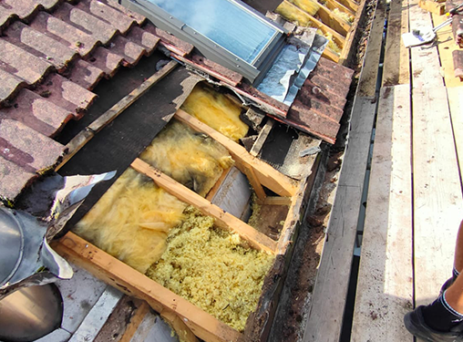 A person is standing on a roof with a lot of insulation on it.