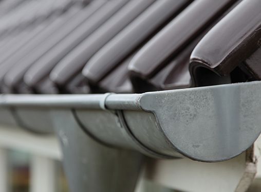 A close up of a metal gutter on a roof.