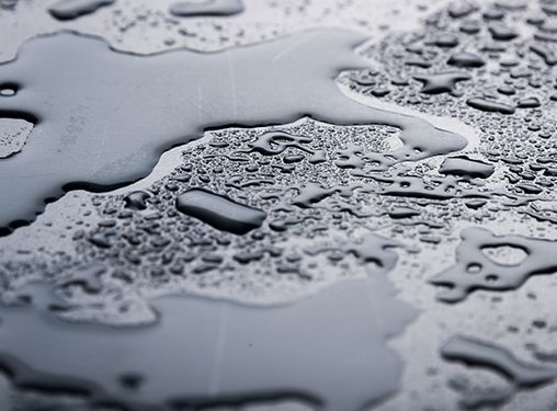 A close up of water drops on a black surface