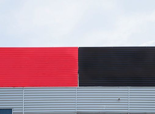 A red and black building with a white sky in the background.