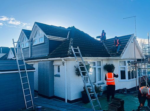 A group of people are working on the roof of a house.