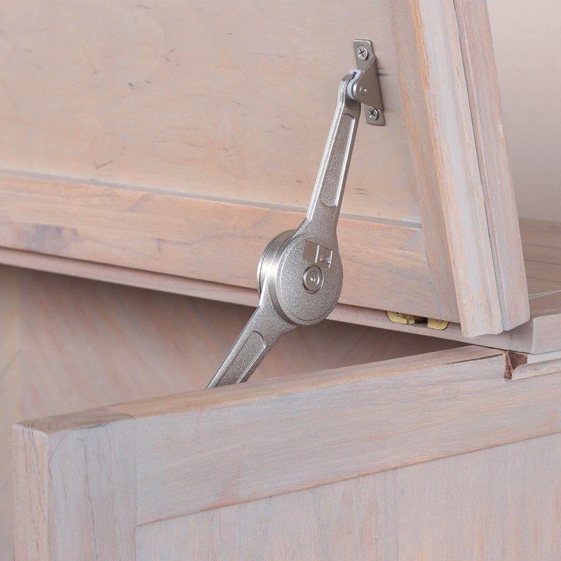 whitewash wood cabinet bed with black iron handles, storage drawer on the bottom and chevron panels front. Close-up of the hardware for opening the top.