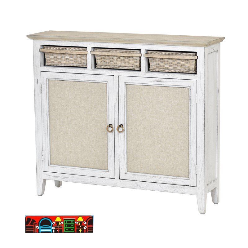 The Captiva Island entrance cabinet features a coastal design with a distressed white and beach sand finish, includes three baskets, two doors with outdoor fabric fronts, woven knobs, and shelves.