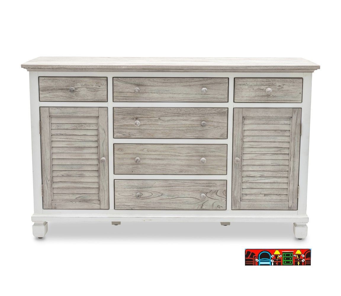 The Islamorada Dresser features a wooden construction with six drawers and two doors, finished in white and distressed grey. It's designed with a coastal theme and includes shutter accents.