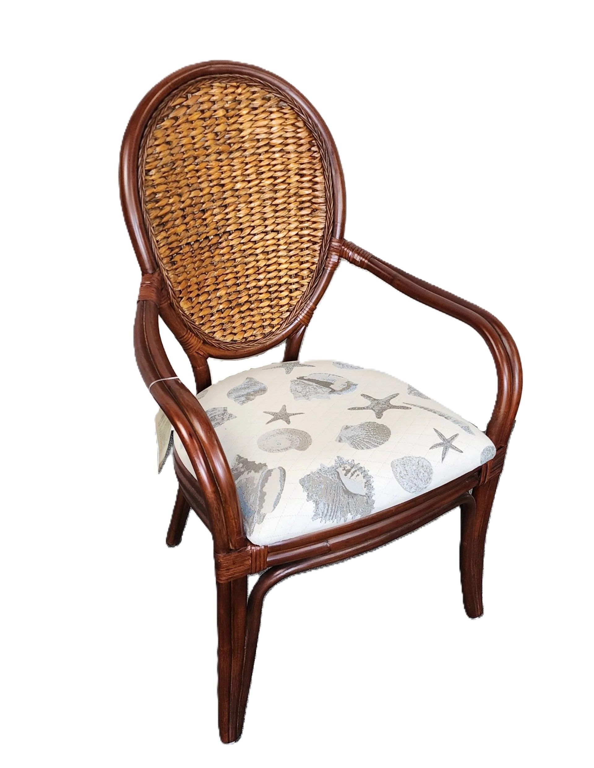 Dark rattan armchair featuring a woven, rounded back and coastal-themed cushions.
