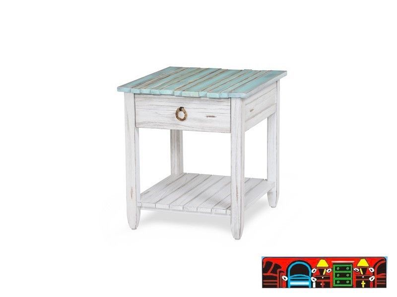 The Picket Fence End Table offers a coastal charm with its solid wood construction, distressed white finish, weathered blue top, and rope pull. Available at Bratz-CFW.
