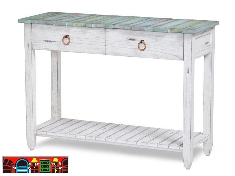 The Picket Fence Sofa Table offers a coastal charm with its solid wood construction, distressed white finish, weathered blue top, and rope pulls. Available at Bratz-CFW.
