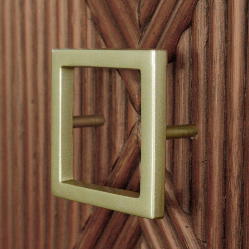Dark brown, sienna finish wood cabinet bed with pencil rattan front panels, iron hardware and storage drawer on the bottom. Close-up of the gold color hardware on the cabinet and the pencil rattan.
