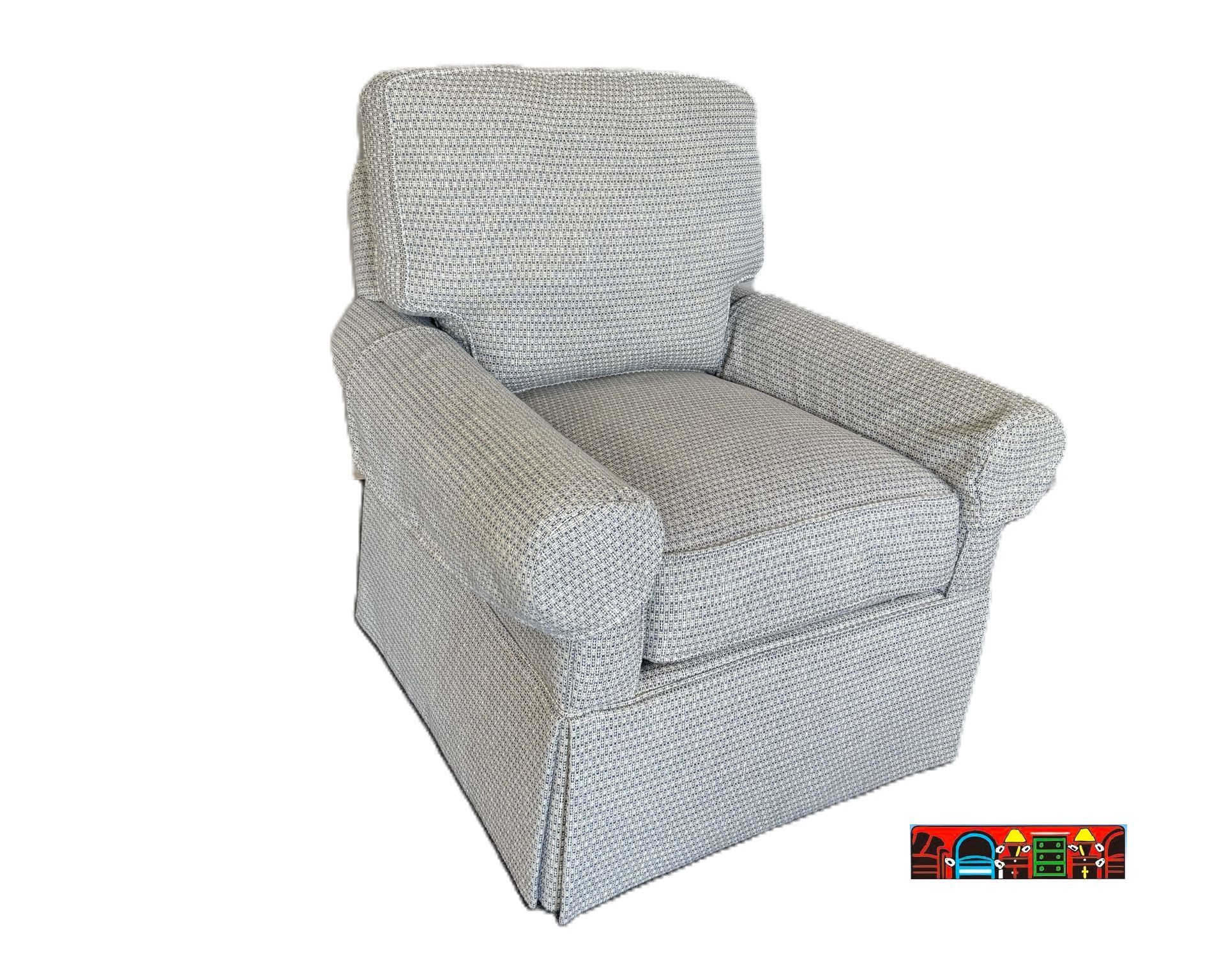 'A gently used club chair upholstered in grey/blue fabric, featuring rolled arms, a skirted base, and reversible cushions. The set includes one stationary chair and one swivel chair.'