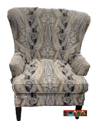 'A gently used club chair with a high, flared back and reversible seat cushion, featuring exposed wooden legs and upholstered in a fabric with grey, black, and off-white tones.'