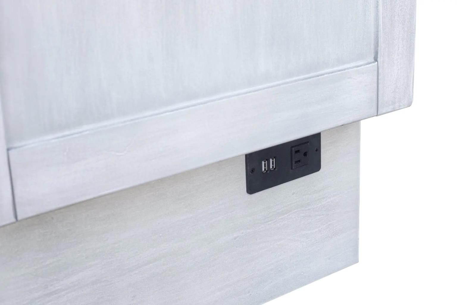 Weathered white wood cabinet bed with large square wooden decorative handles. Large drawer at the bottom. Close-up of the side with power supply.