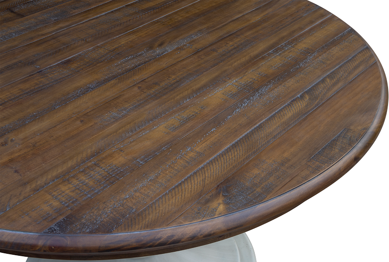 The Brockton Round Dining Table features a solid pedestal base, finished in wheat with a dark brown top. Both with a distressed look. Top Close-up.