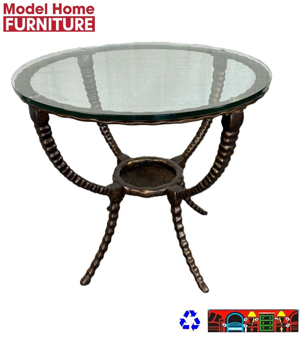 'This model-home round accent table features a hammered iron base with four legs converging at the center, from which four arched arms extend to support a 28