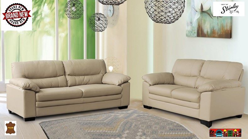 'This sofa & loveseat features attached pillow-backs, a two-seat cushion design, pillow arms, flat sides, and dark brown feet. It is upholstered in top-grain cow leather wherever the body touches.'