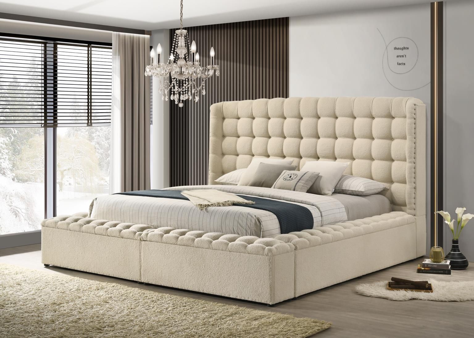 Beige completely upholstered storage bed with high headboard, tufted surround and nail head accents.