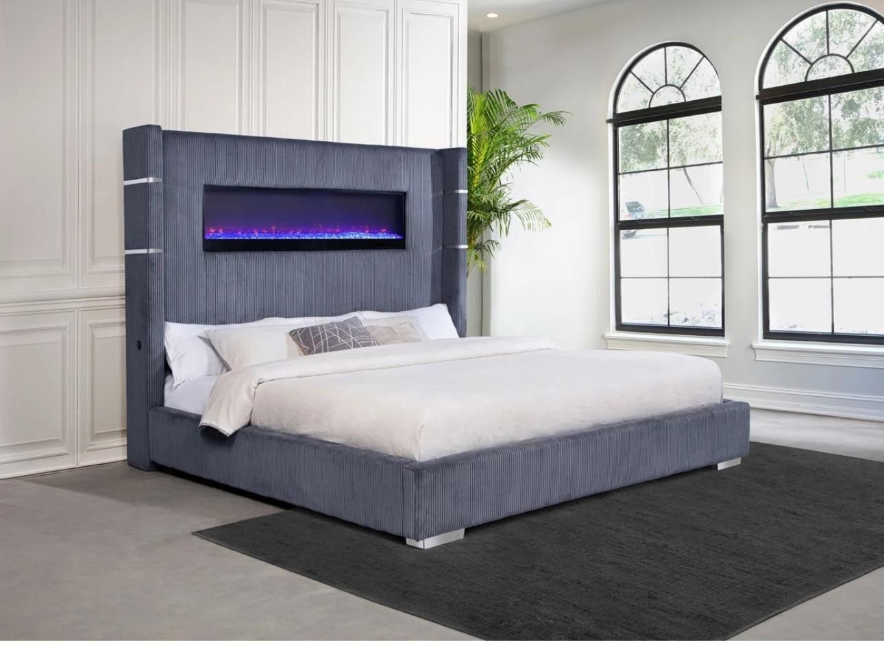 grey upholstered bed with high Headboard, silver accents and faux fireplace in the headboard