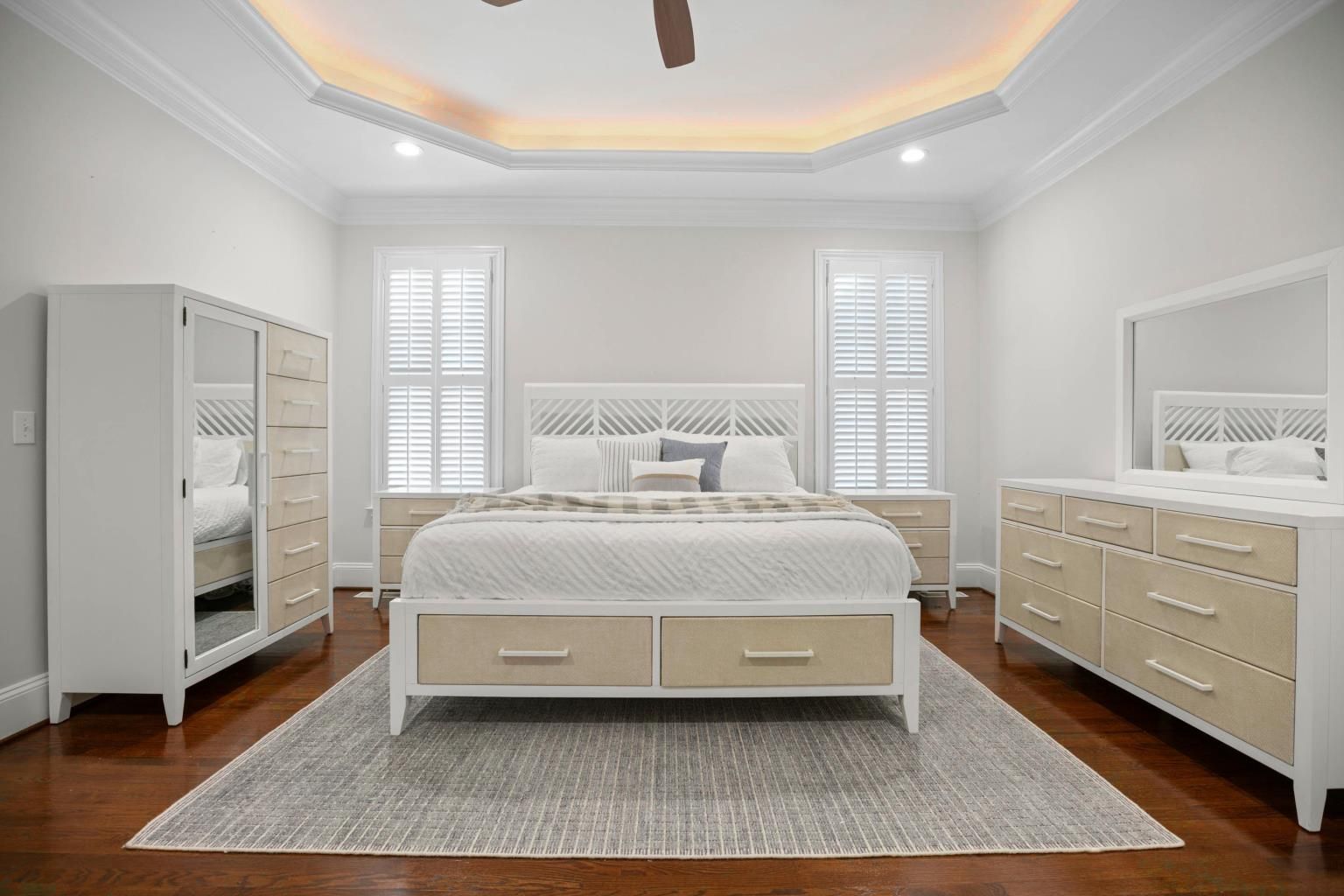 The Miramar bedroom set. White with woven sand color accents.  A 7-drawer dresser, all white mirror, king storage bed with 2 drawers at the foot. two 3-drawer nightstands and a chest with a marron on the left side and 6 drawers stacked on the right side