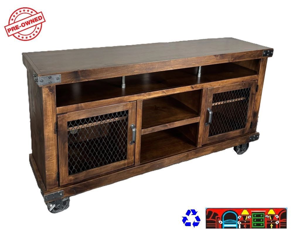 This rustic TV stand is made of solid wood and has a medium brown color. It has cast wheels for easy mobility and two doors with metal wire fronts and cast metal accents. It also has three cubbies on the top and two shelves in the center.
