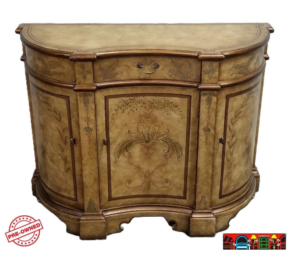Entrance console in wood, featuring a faux cream and brown paint finish with hand-painted accents, designed in a half-moon shape, with three doors and one drawer, is available at Bratz-CFW in Fort Myers, FL.