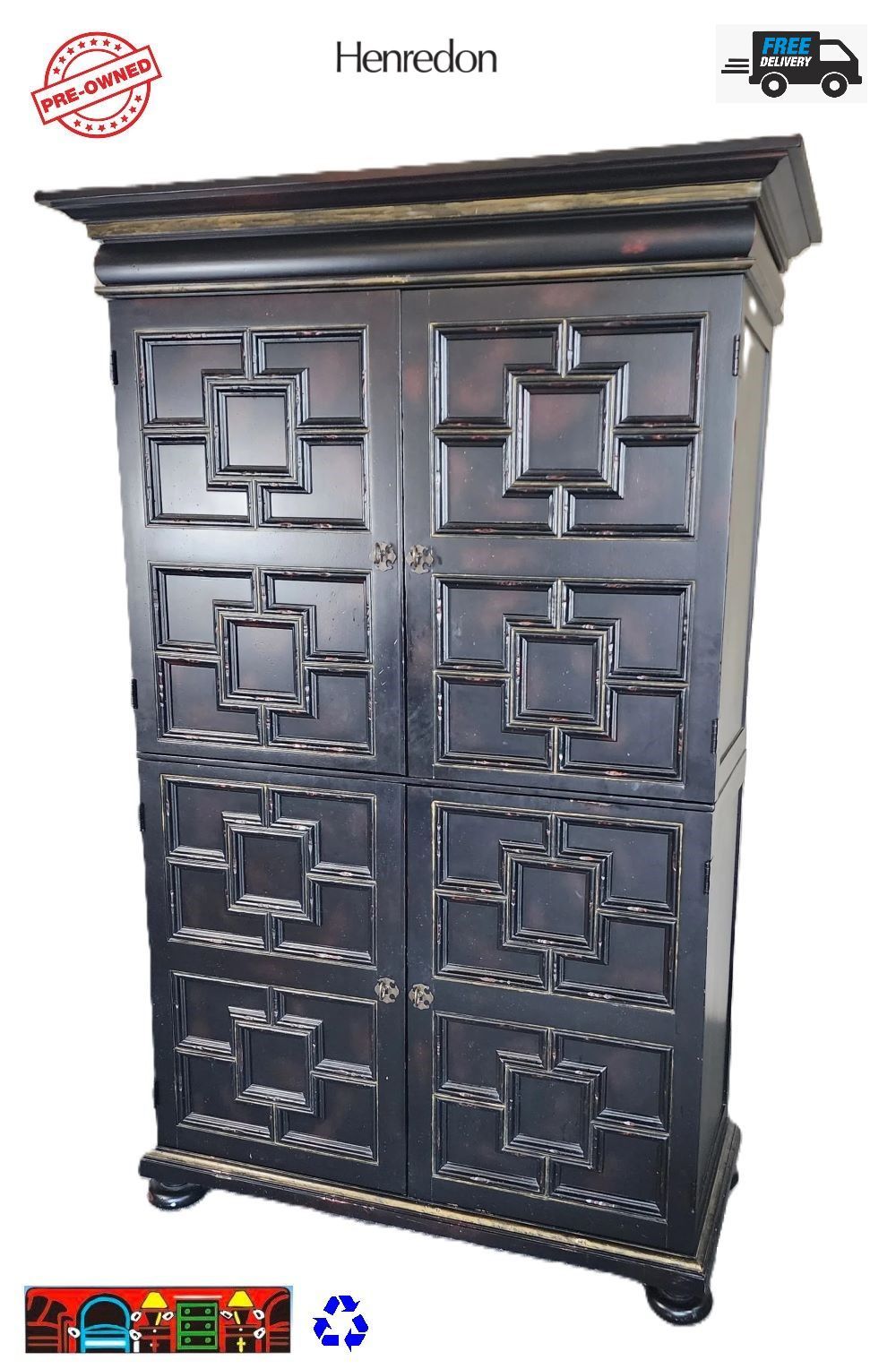 This is a Henredon armoire made of black wood and decorated with red and gold accents. It has four doors with raised wood trim designs, three shelves and two drawers inside.