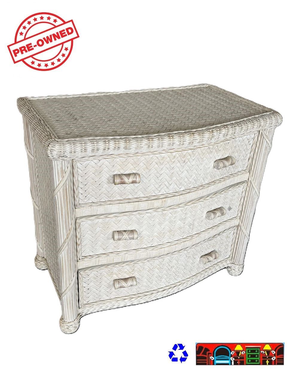 A bedroom chest made of wicker with four drawers and a curved front, painted whitewash.