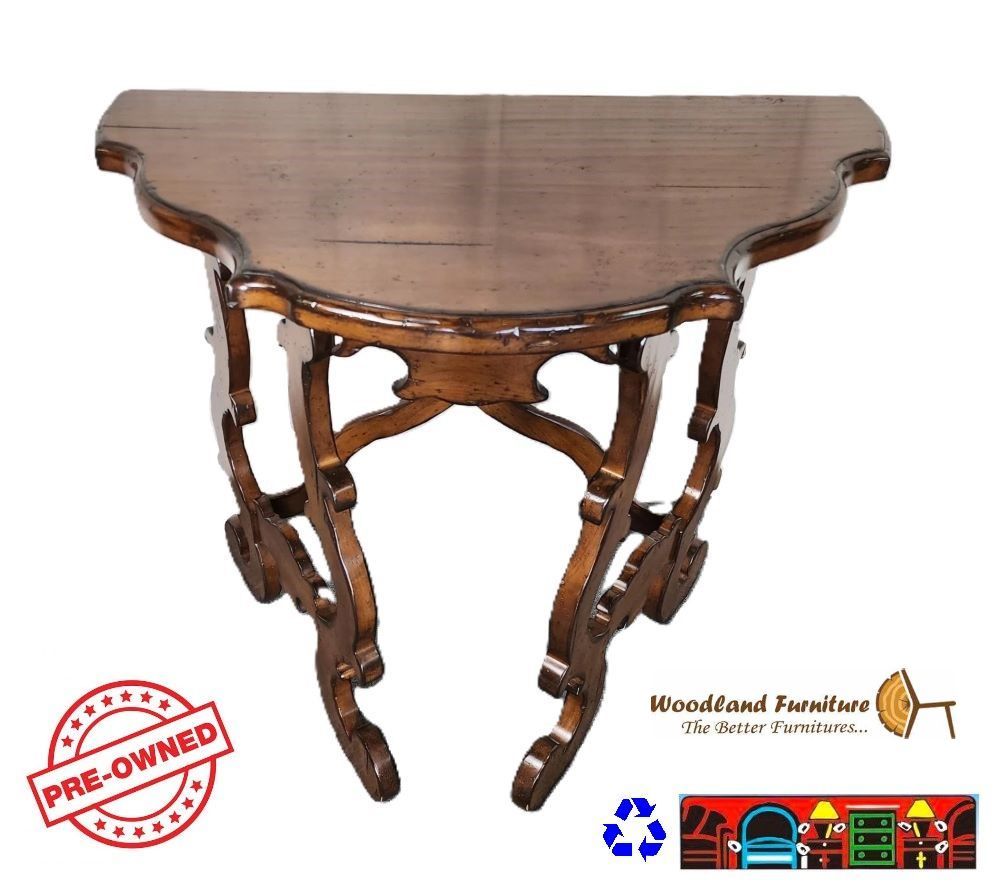 'A gently used Woodland console table featuring a half-moon shape, crafted from solid wood with a medium brown finish. It boasts curved details along the top edges and legs.'
