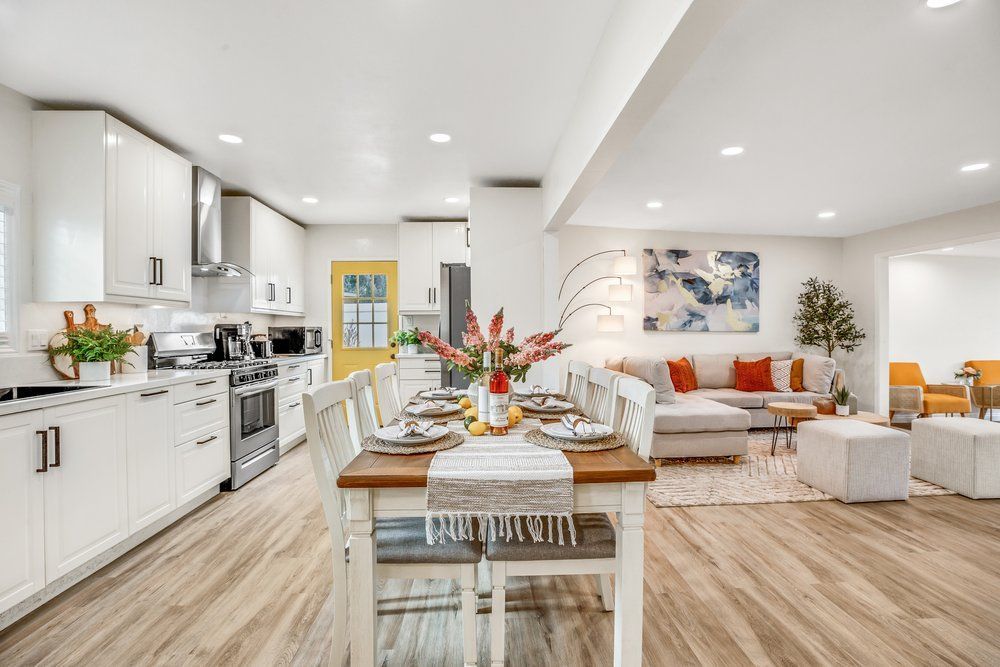 A kitchen and dining room in a house with a table and chairs.