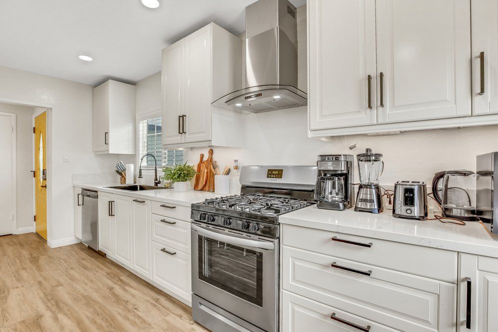 A kitchen with white cabinets and stainless steel appliances.