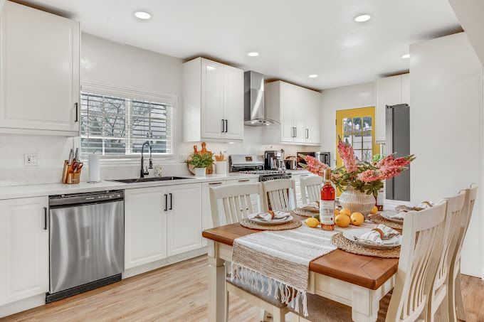 A kitchen with a dining table and chairs in it.