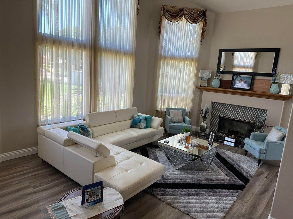 A living room with a couch , chairs , coffee table and fireplace.