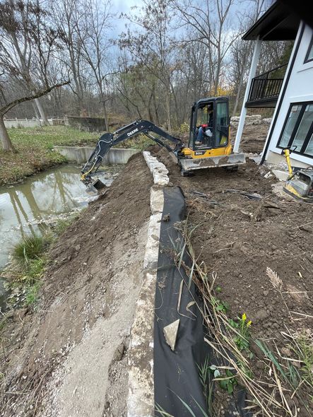 Landscaping, ditch clean-up, rock barrier wall to prevent house wash out with mini excavator