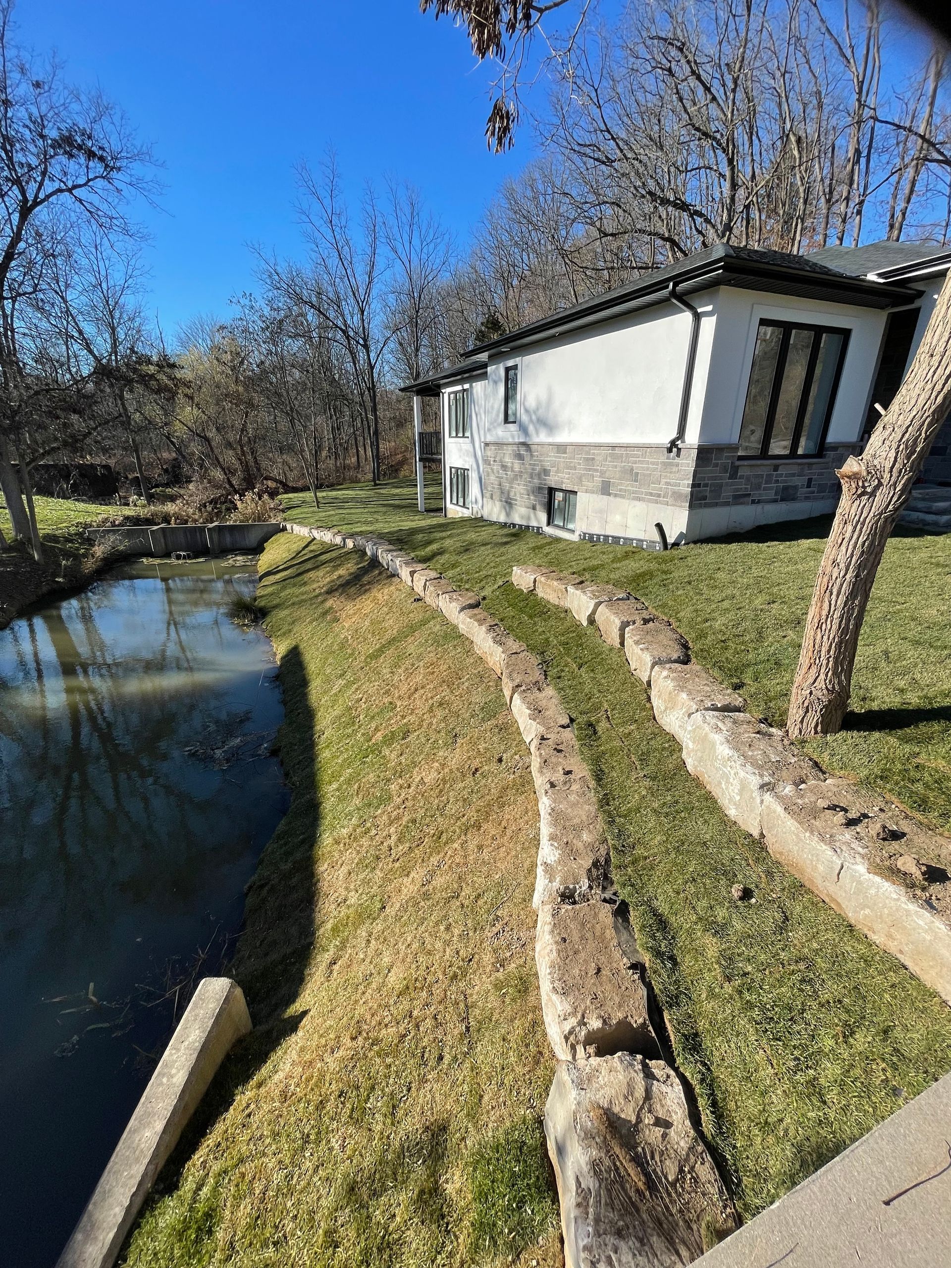 Completed project of large stone work. Excavator used to place rocks to prevent house wash out into the river.