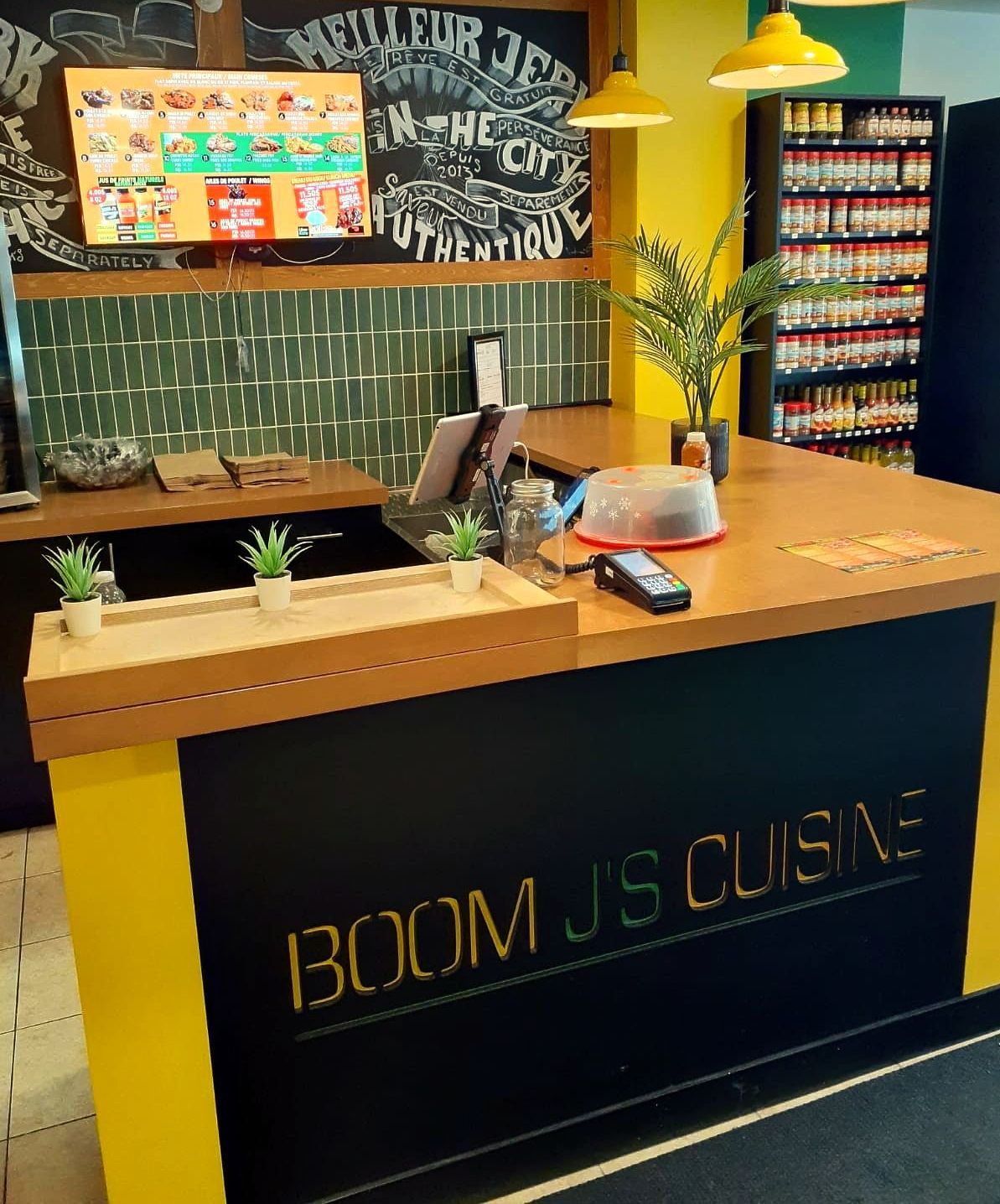 A counter in a restaurant that says boom js cuisine