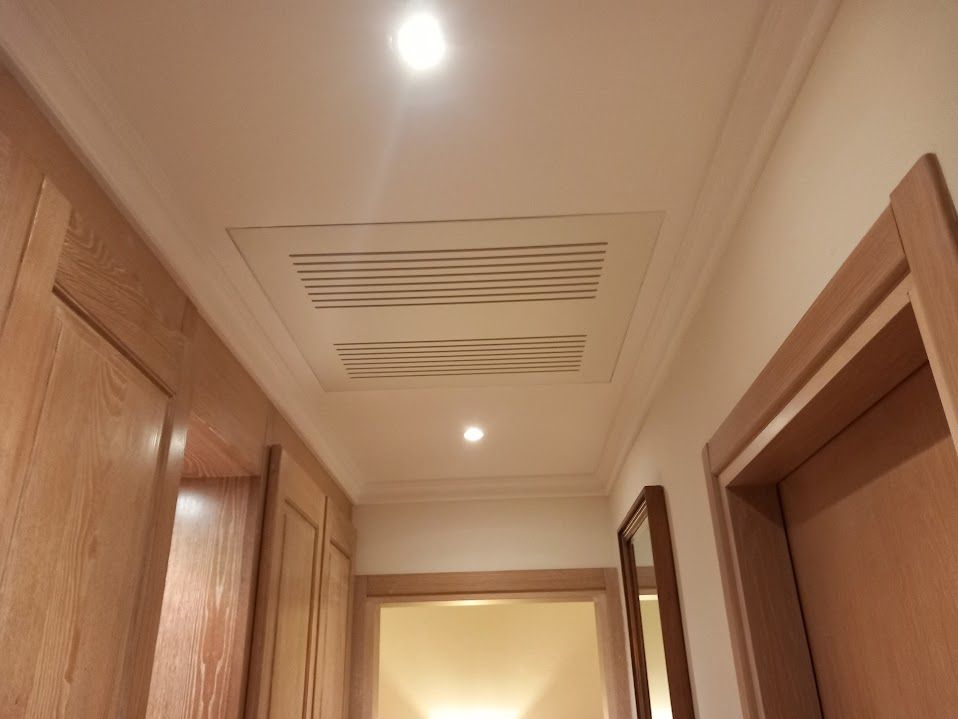 Controsoffitto del corridoio con bocchetta di ventilazione incassata, due luci incassate e stipiti delle porte in legno.
