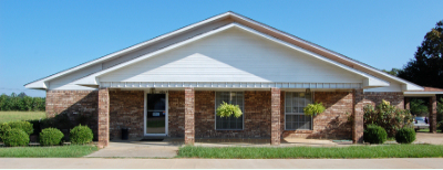 A brick building with white trim under a bright blue sky.