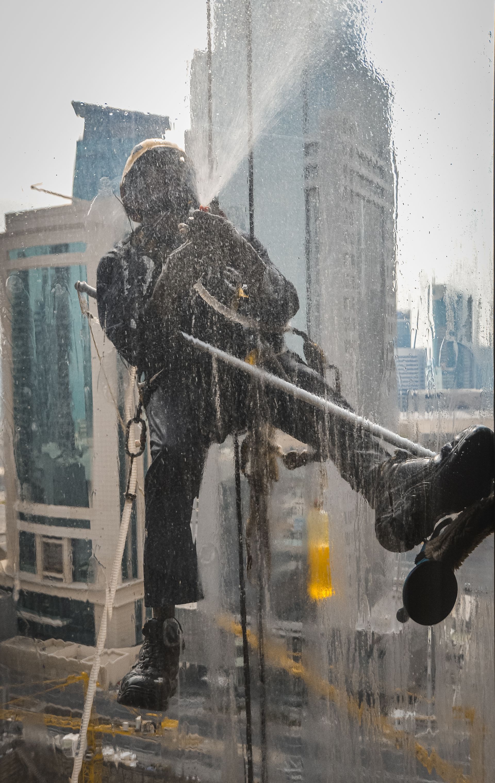 Un homme nettoie une fenêtre avec un nettoyeur haute pression.