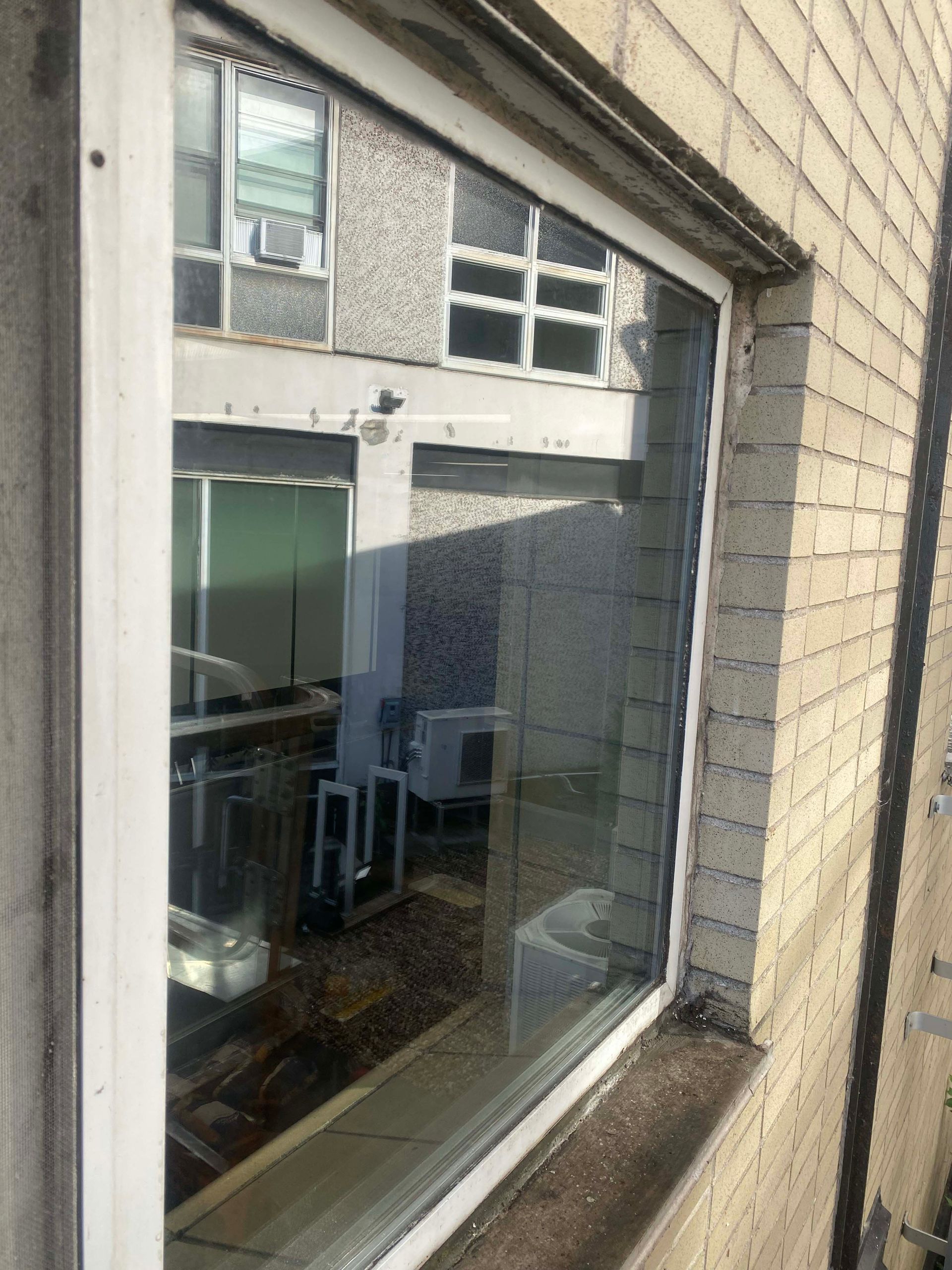 Une fenêtre sur un bâtiment en briques avec un cadre blanc