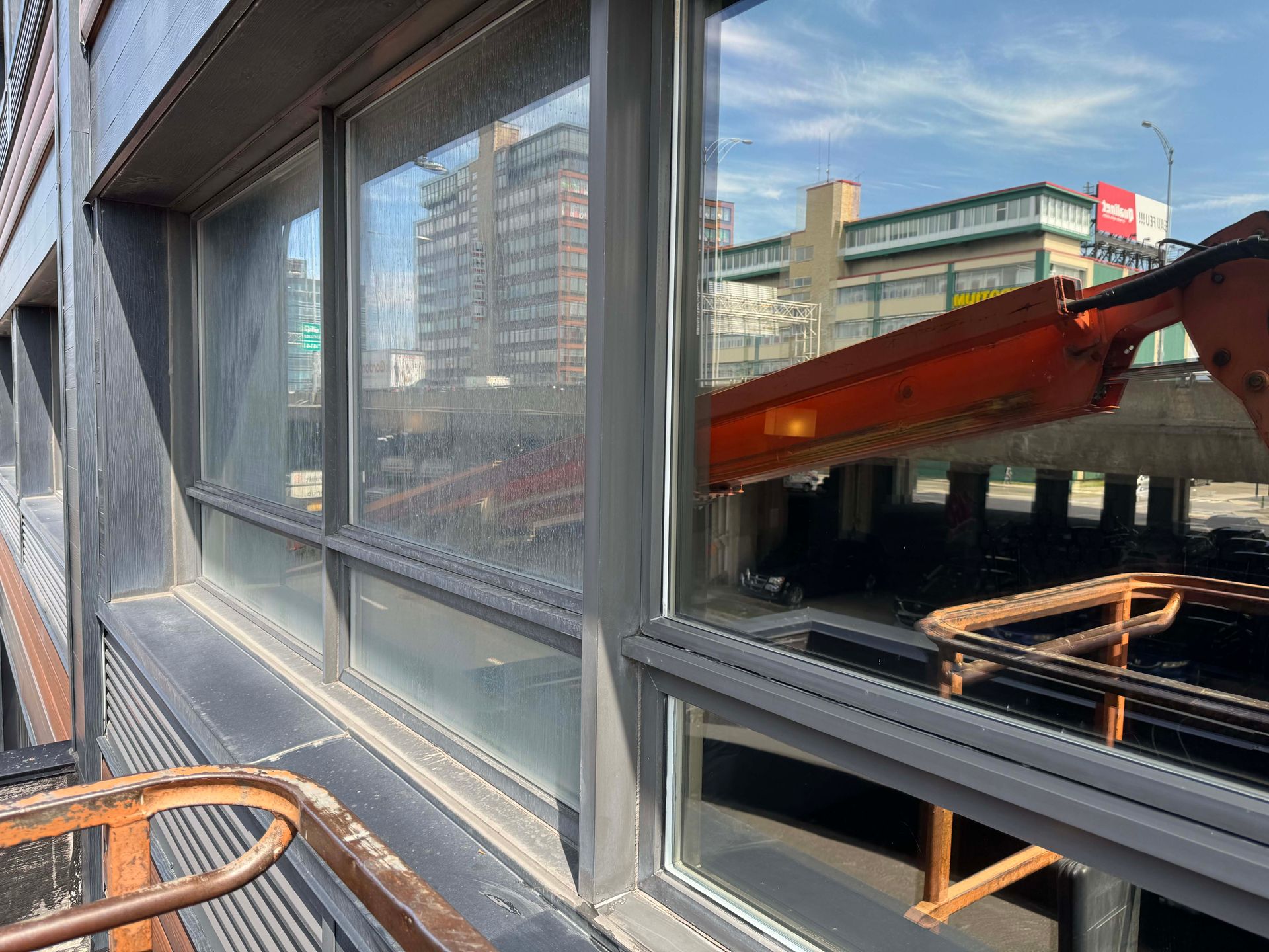 Un bâtiment avec beaucoup de fenêtres et une grue en arrière-plan.