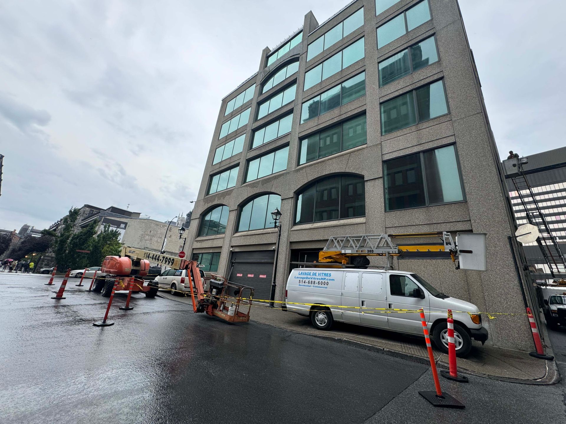 Une camionnette blanche est garée devant un grand bâtiment