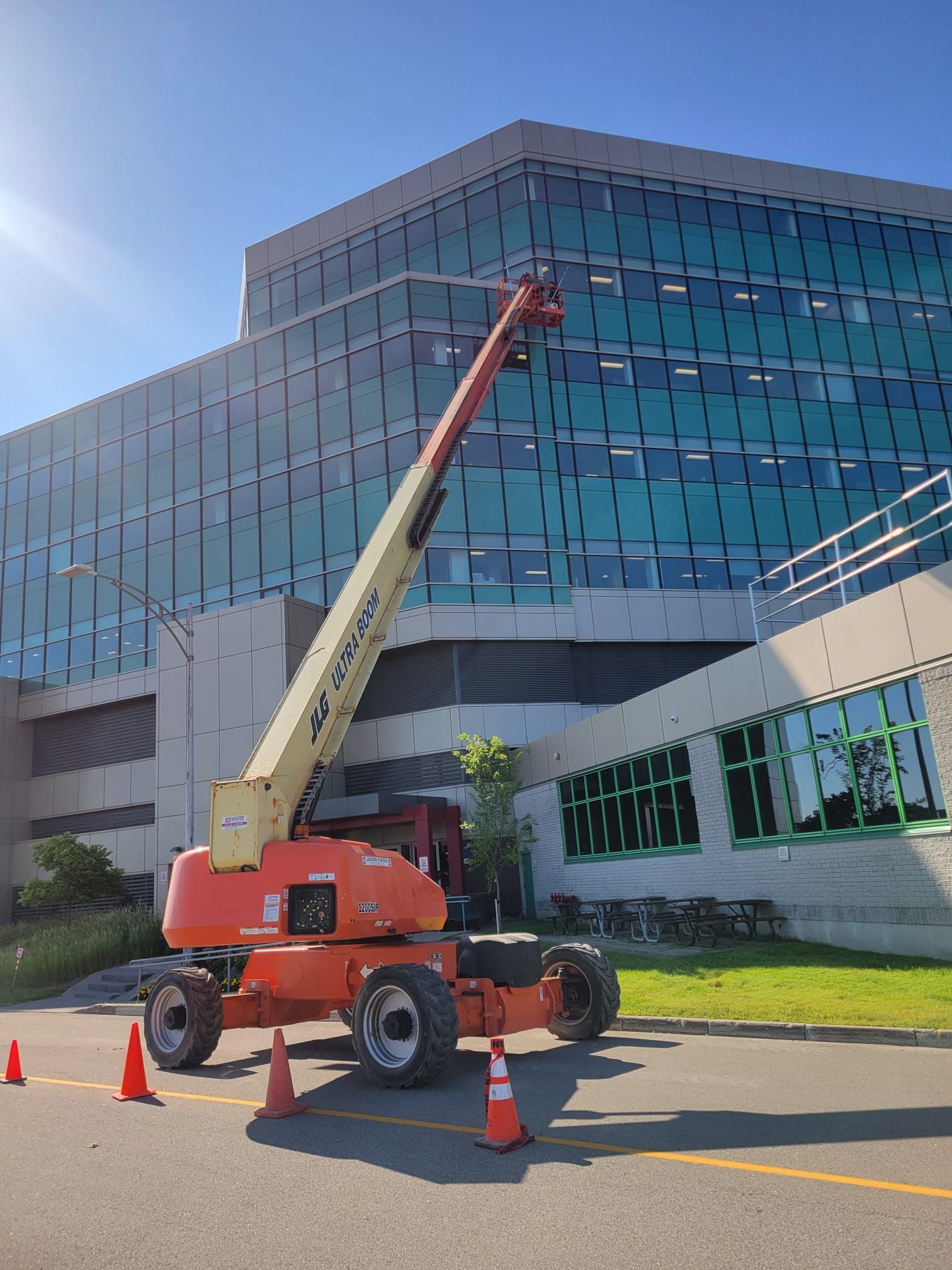 Une grue est garée devant un grand bâtiment.
