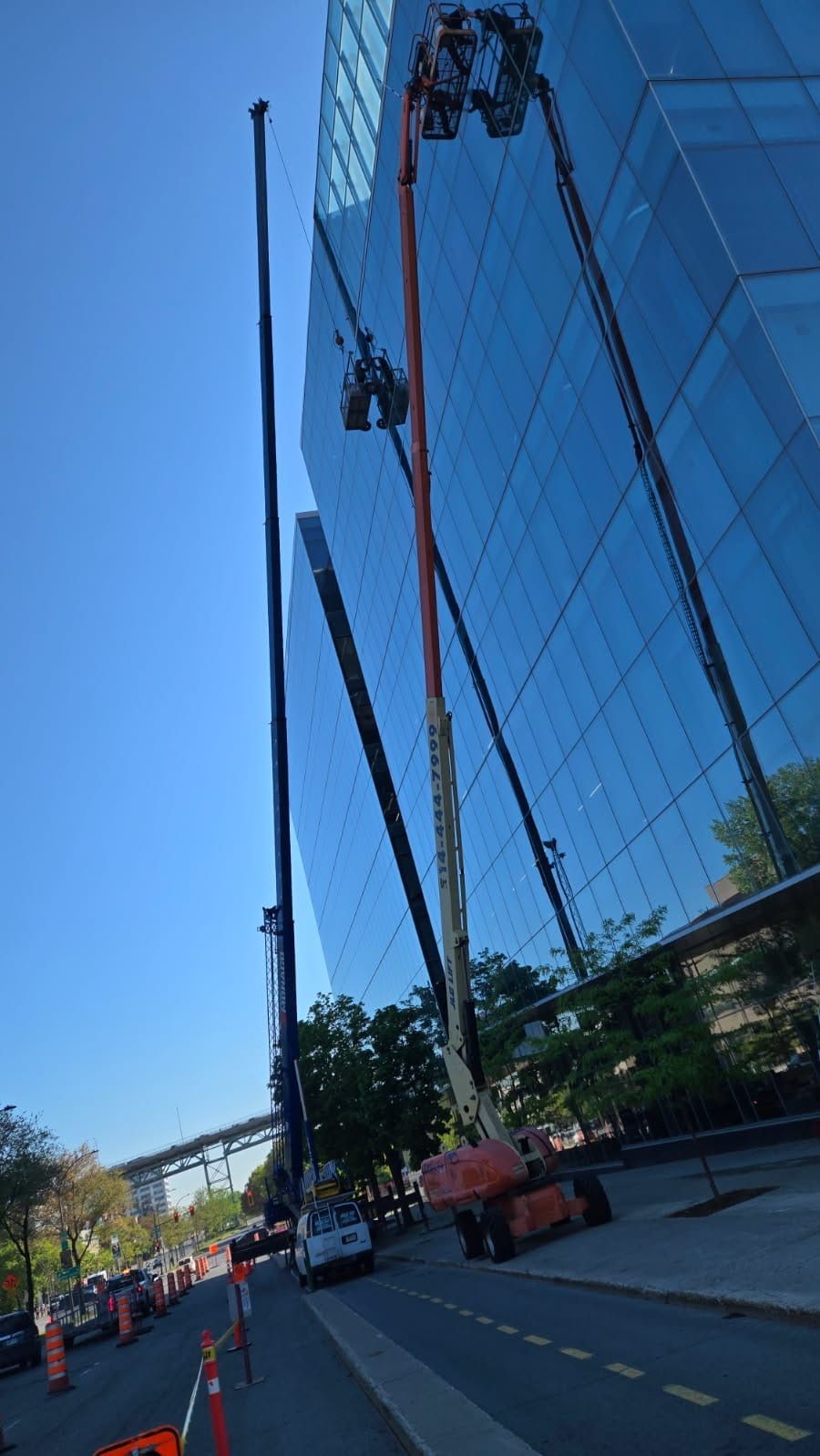 Une grue est utilisée pour nettoyer les fenêtres d'un grand immeuble.