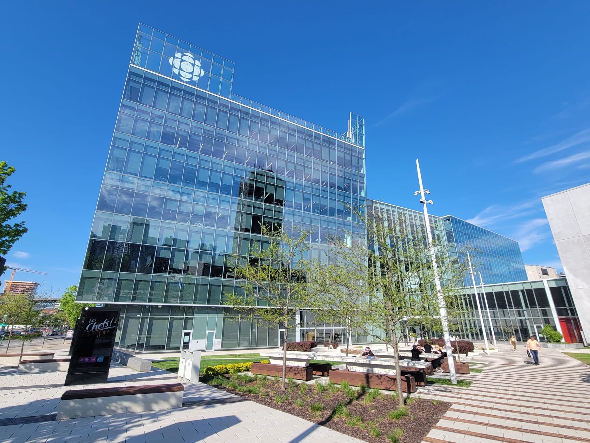 Un grand bâtiment en verre avec un ciel bleu en arrière-plan.
